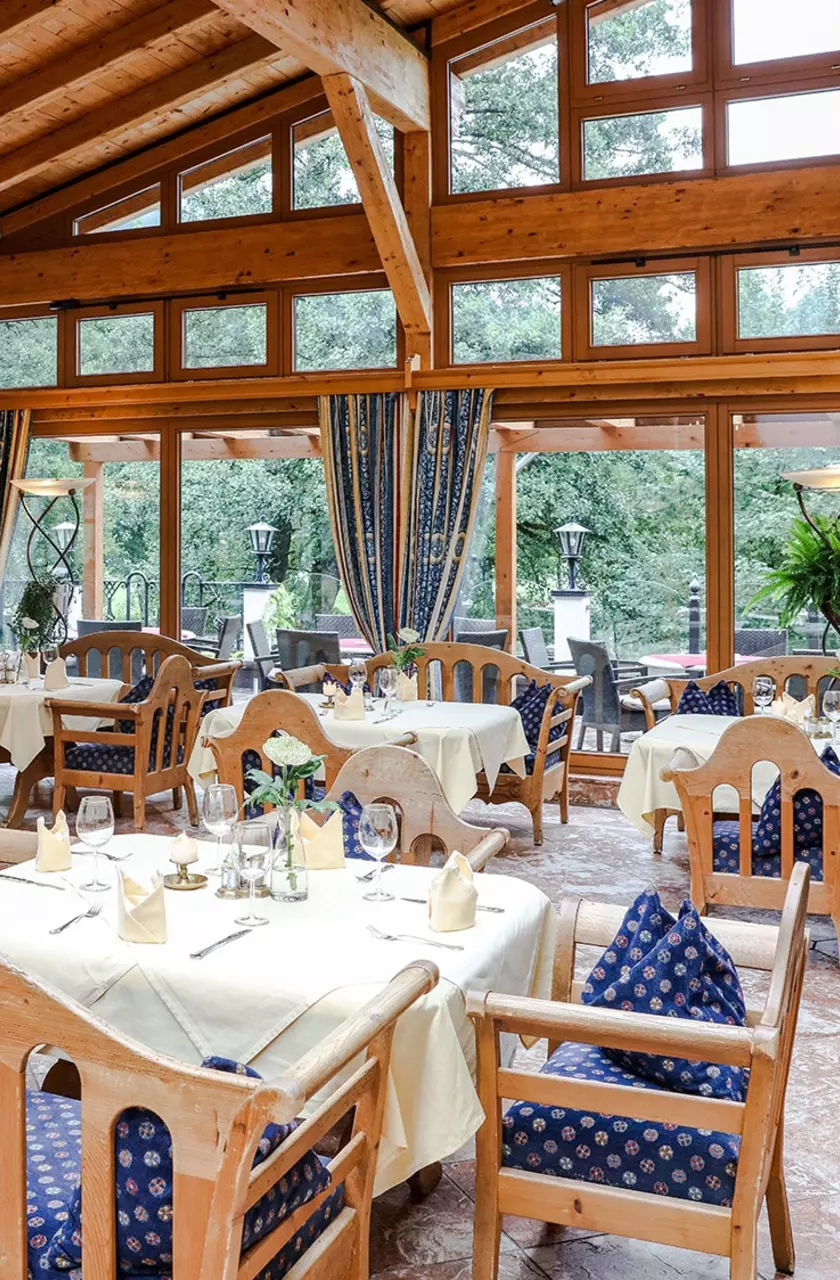 Restaurant im Wintergarten mit hölzerner Daschschräge, großer Glasfront und Balkon