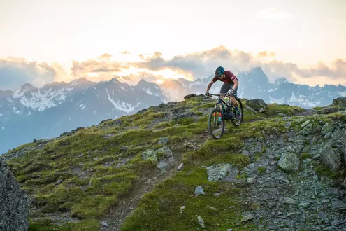 Radfahrer mit Helm und E-Bike beim Mountainbiken in den Bergen im Sommer
