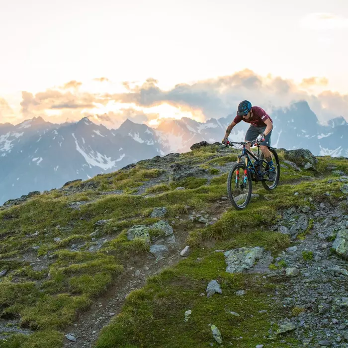 Radfahrer mit Helm und E-Bike beim Mountainbiken in den Bergen im Sommer