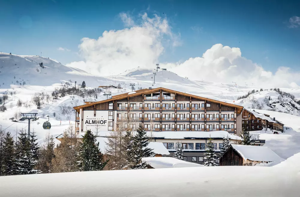 Panoramahotel Almhof in einem verschneiten Skigebiet in den Bergen im Winter