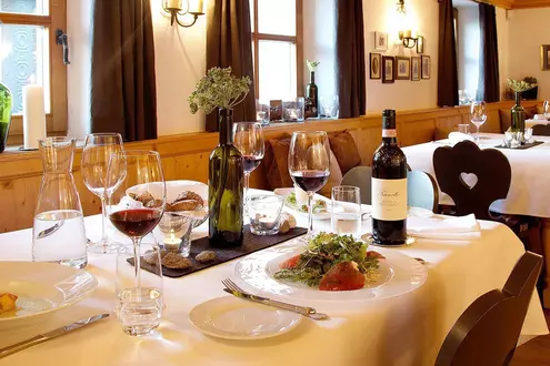 Festlich gedeckter Tisch im Restaurant mit frisch zubereiteten Gerichten und Rotwein