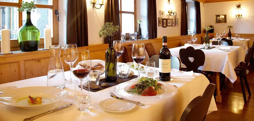 Festlich gedeckter Tisch im Restaurant mit frisch zubereiteten Gerichten und Rotwein