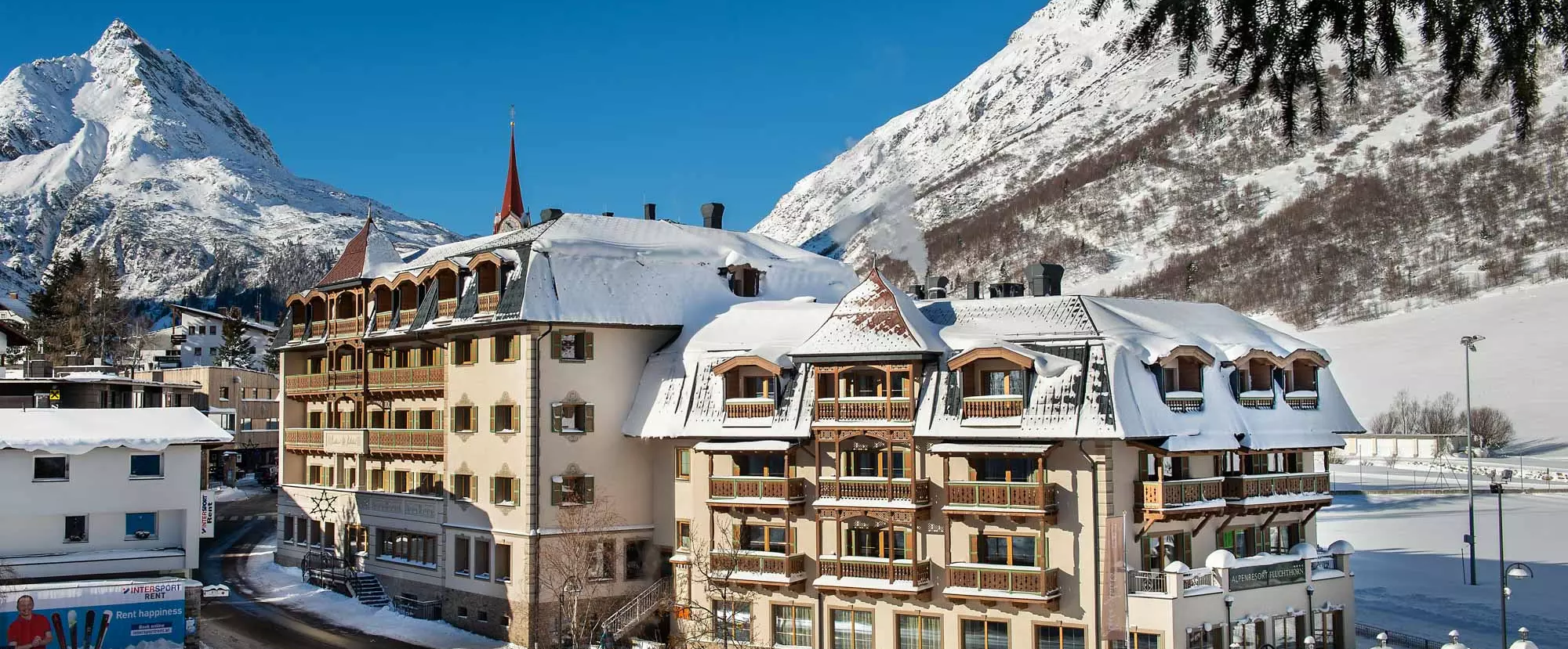 Alpenresort Fluchthorn im Winter mit Blick auf die verschneiten Berge bei Sonnenschein